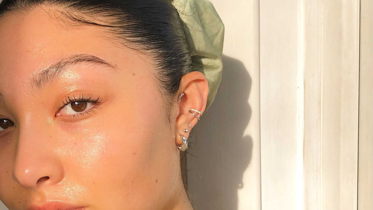 Woman showing off her left ear stacked & styled with silver molten jewellery piercings from Astrid & Miyu