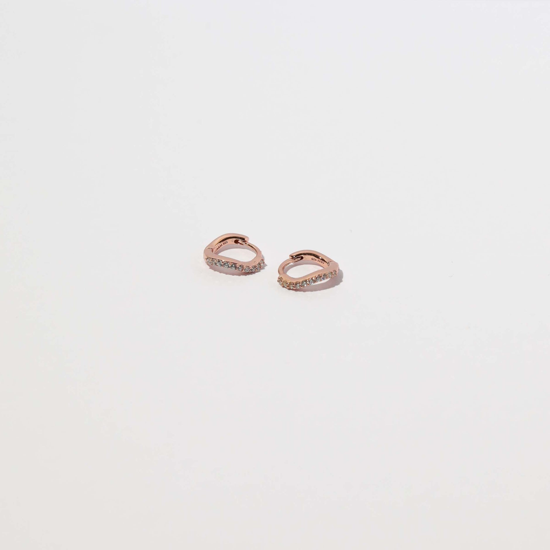 Wave Crystal Huggies in Rose Gold flat lay