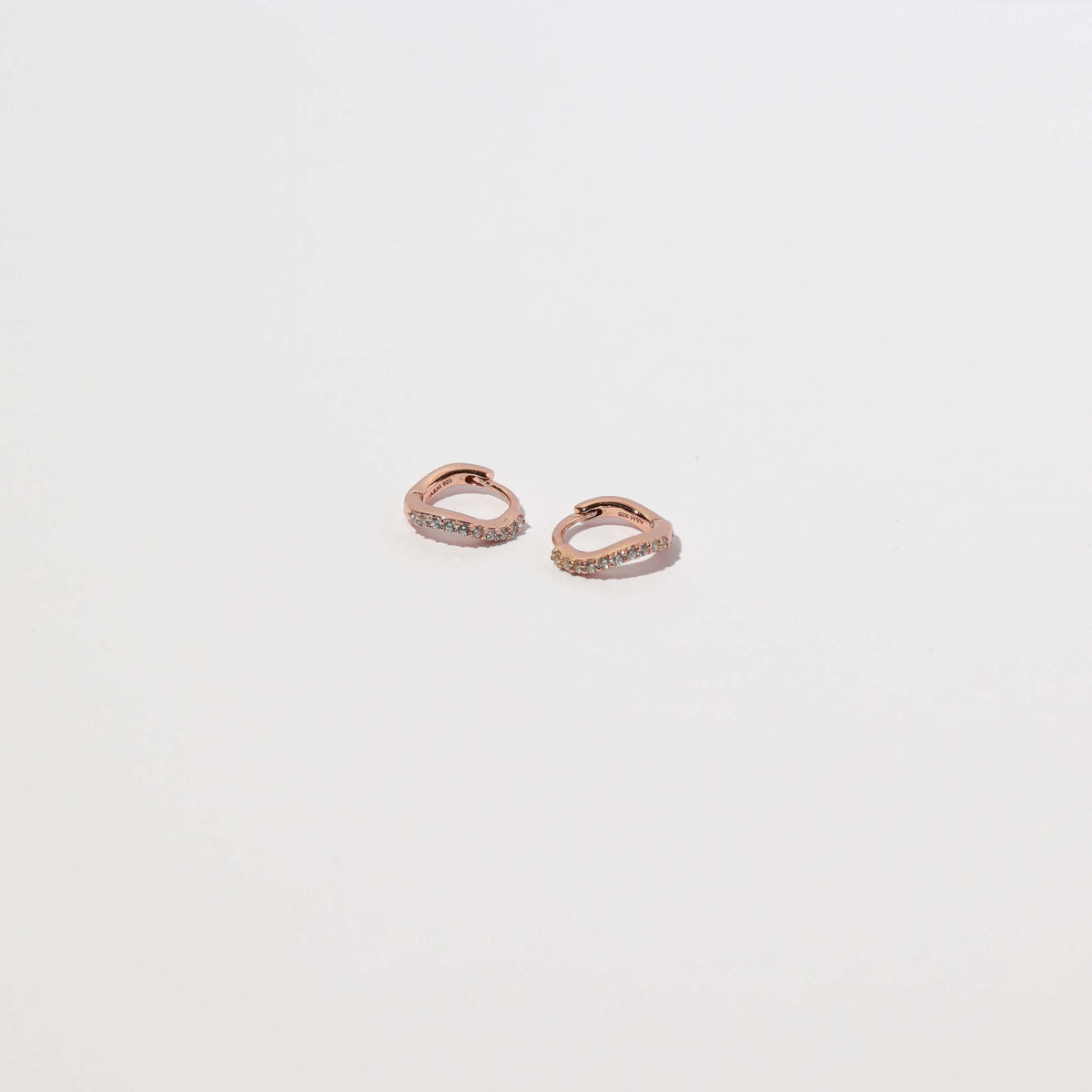 Wave Crystal Huggies in Rose Gold flat lay