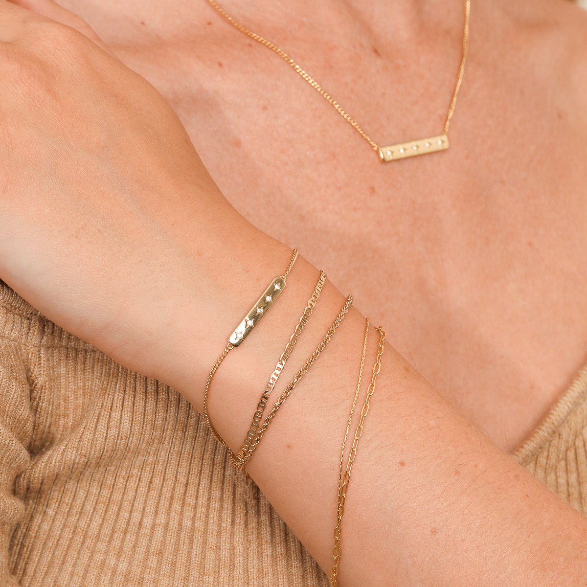 Cosmic Star Bar Bracelet in Gold worn stacked with other bracelets