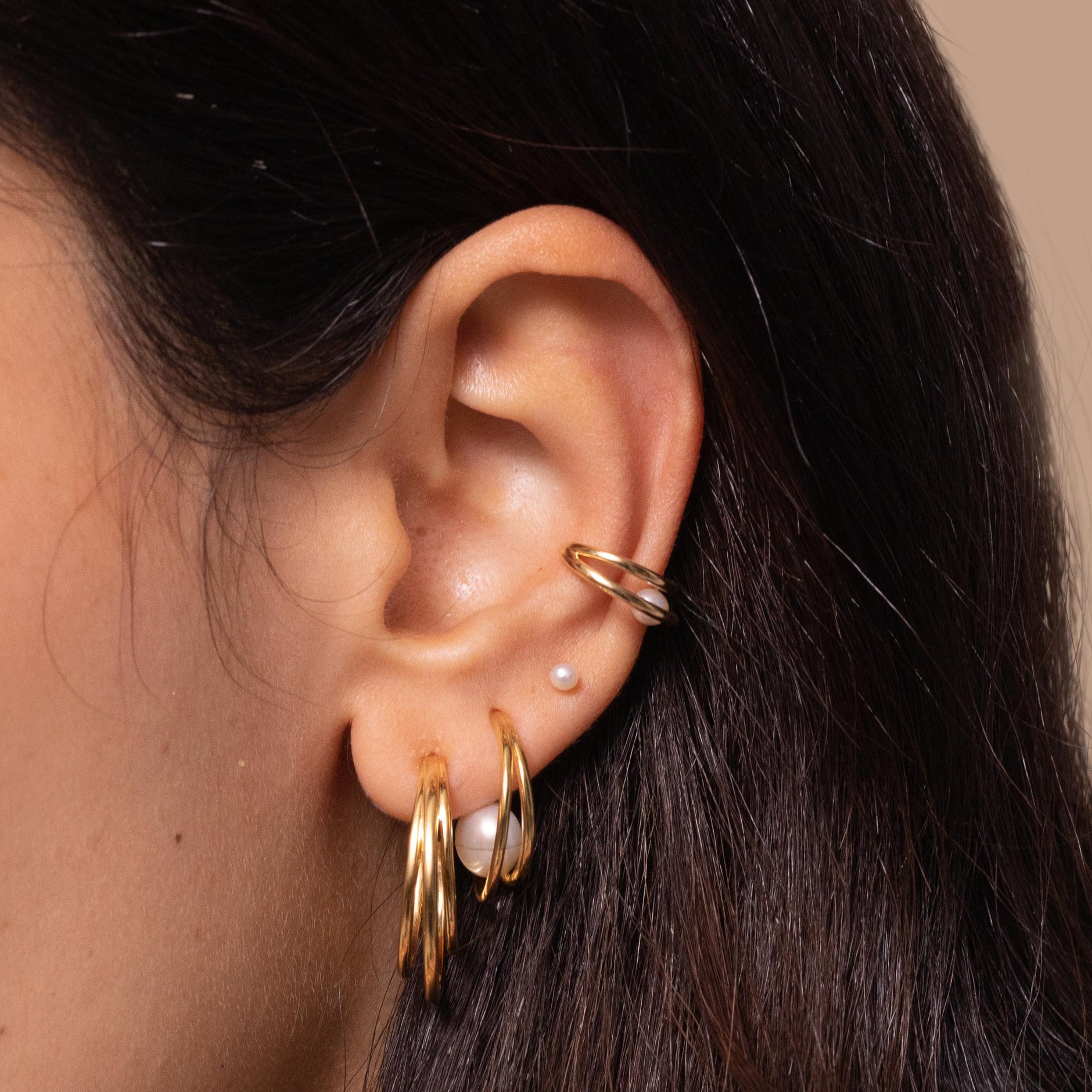 Opulent Pearl Hoops in Gold worn with other earrings