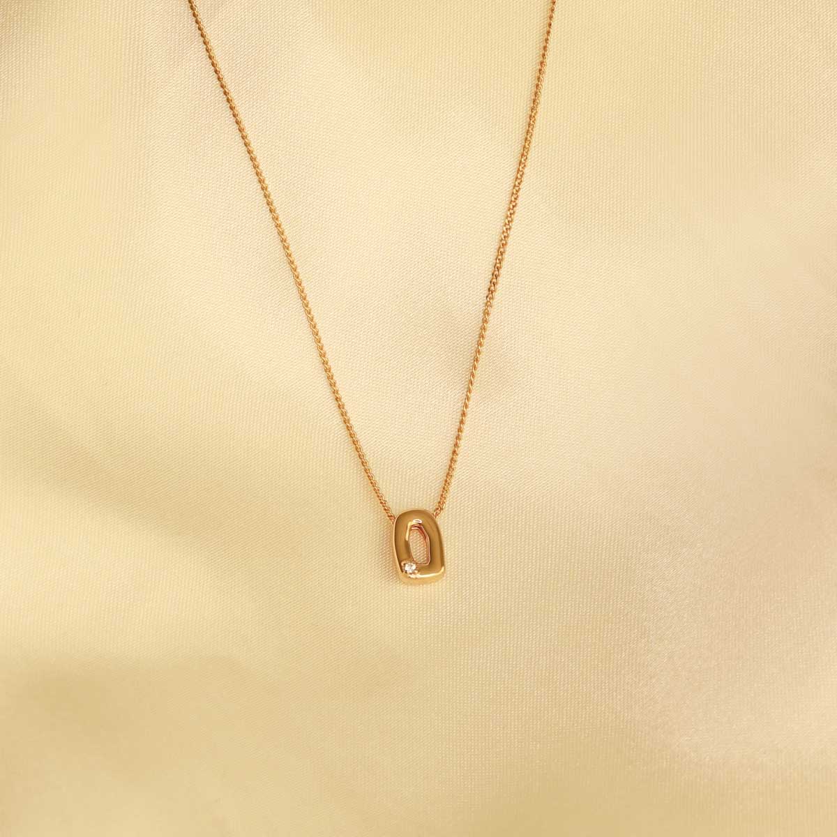 Flat lay shot of O Initial Pendant Necklace in Gold