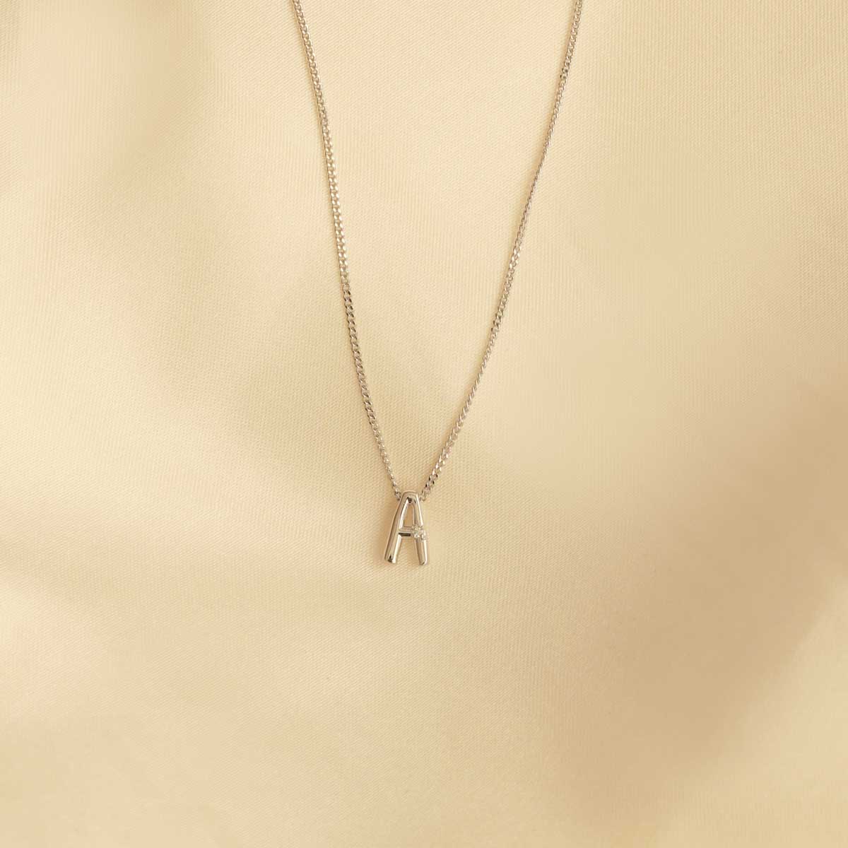 Flat lay shot of A Initial Pendant Necklace in Silver