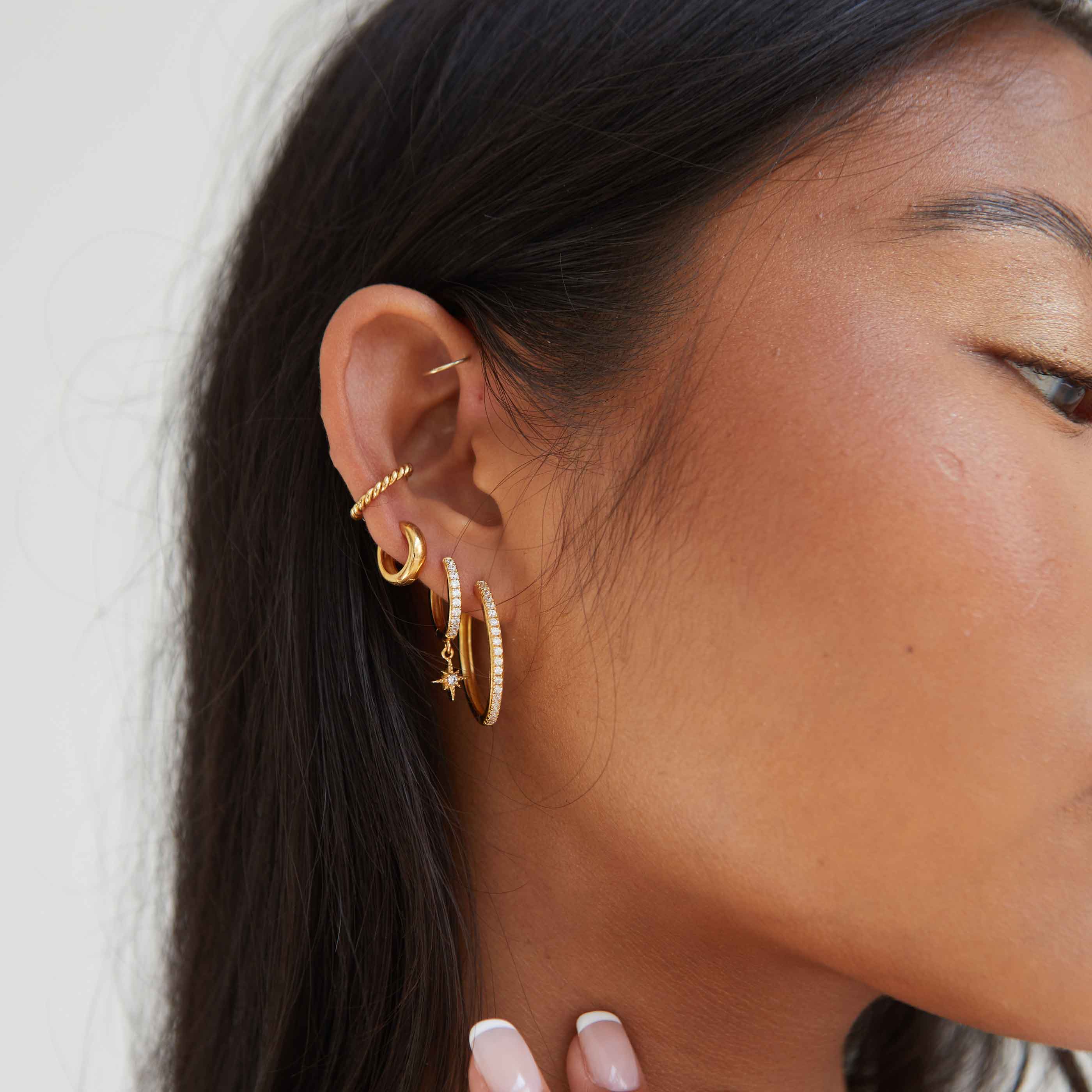 Crystal Star Hoops in Gold worn with other gold earrings