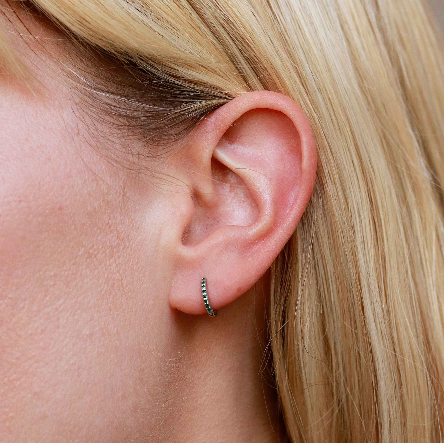Emerald Green Jewelled Huggies in Silver worn in lobe piercing