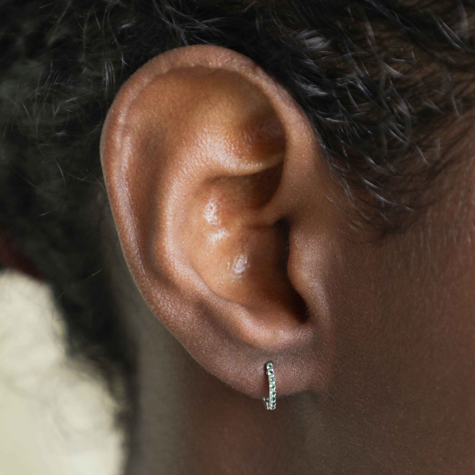 Emerald Green Jewelled Huggies in Silver worn in lobe piercing
