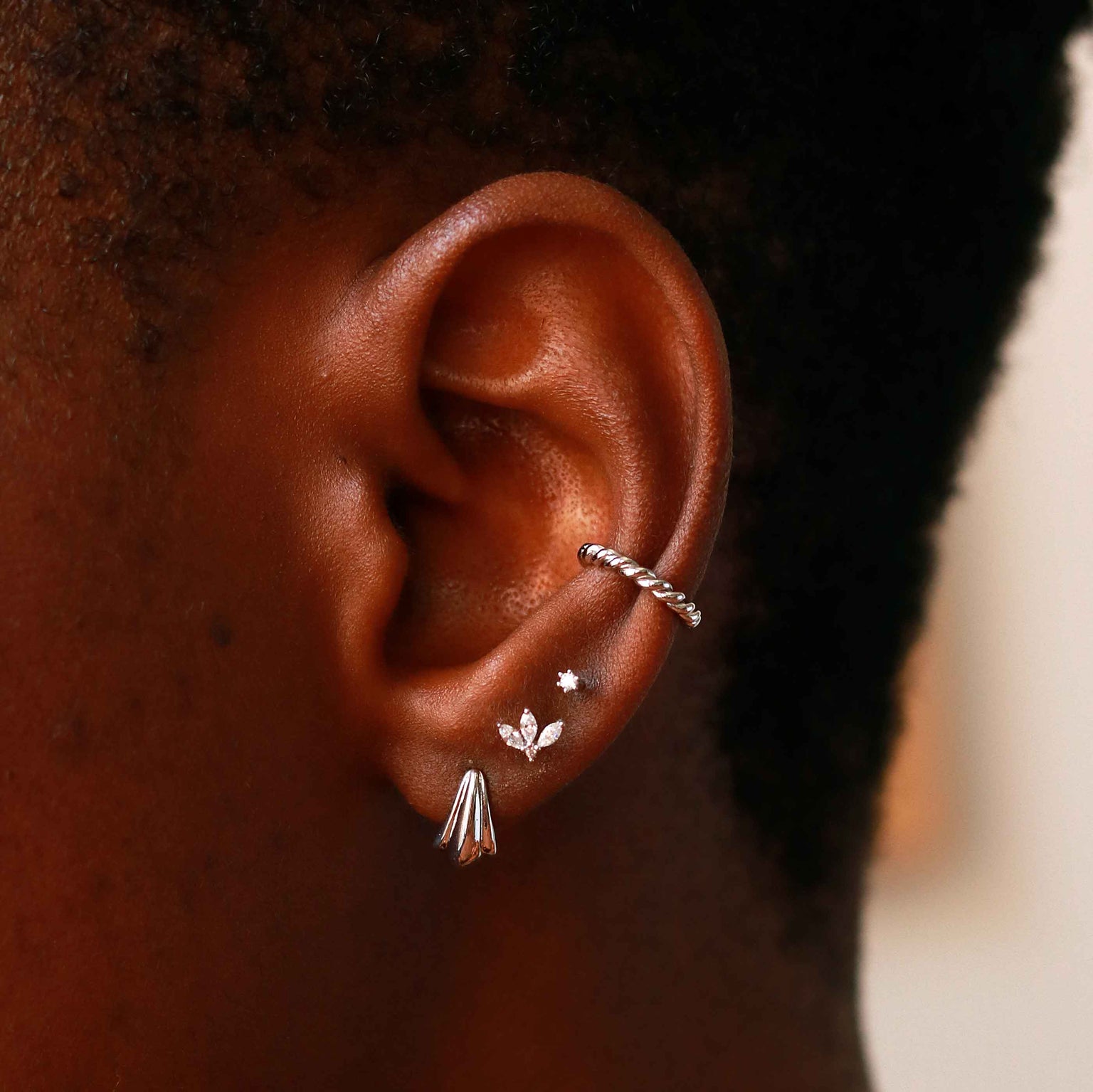 Flora Tiny Barbell in Silver worn in third lobe piercing