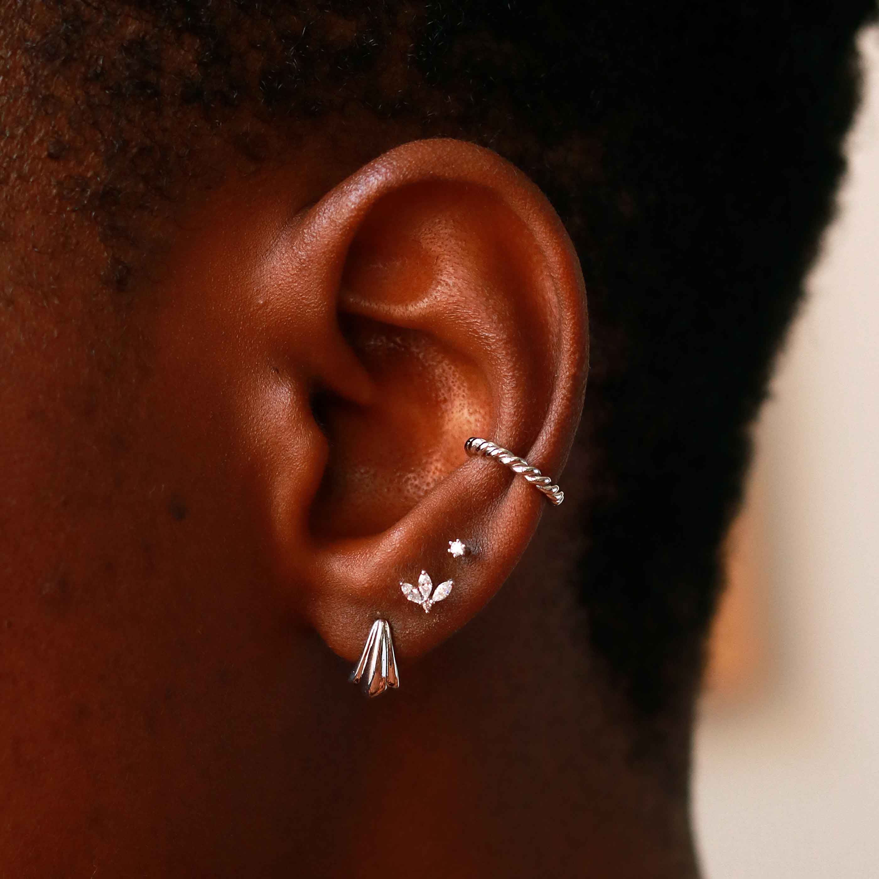 Flora Tiny Barbell in Silver worn in third lobe piercing