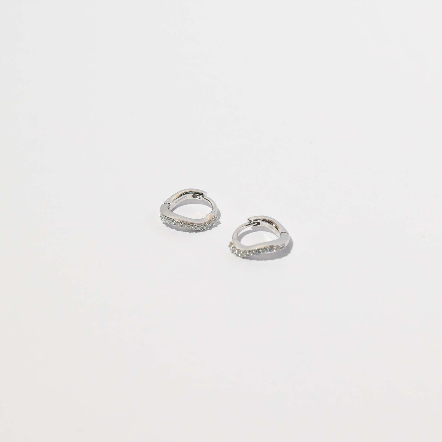 Wave Crystal Huggies in Silver flat lay