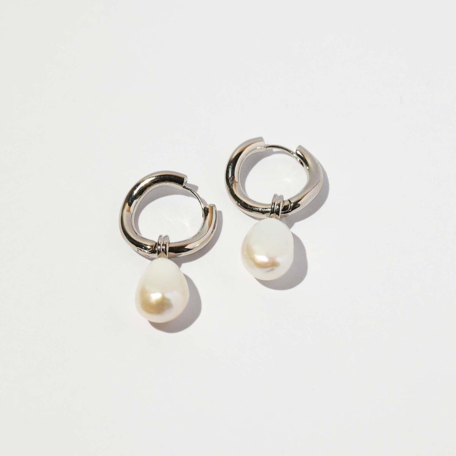 Serenity Pearl Charm Hoops in Silver flat lay