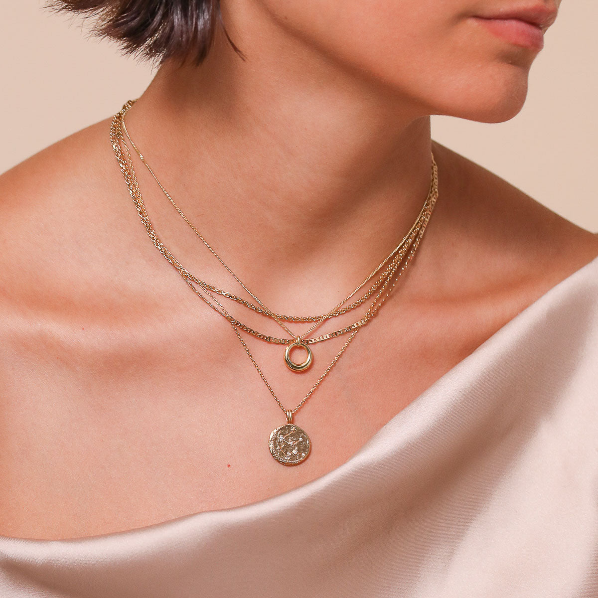 Aquarius Zodiac Pendant Necklace in Gold worn layered with necklaces