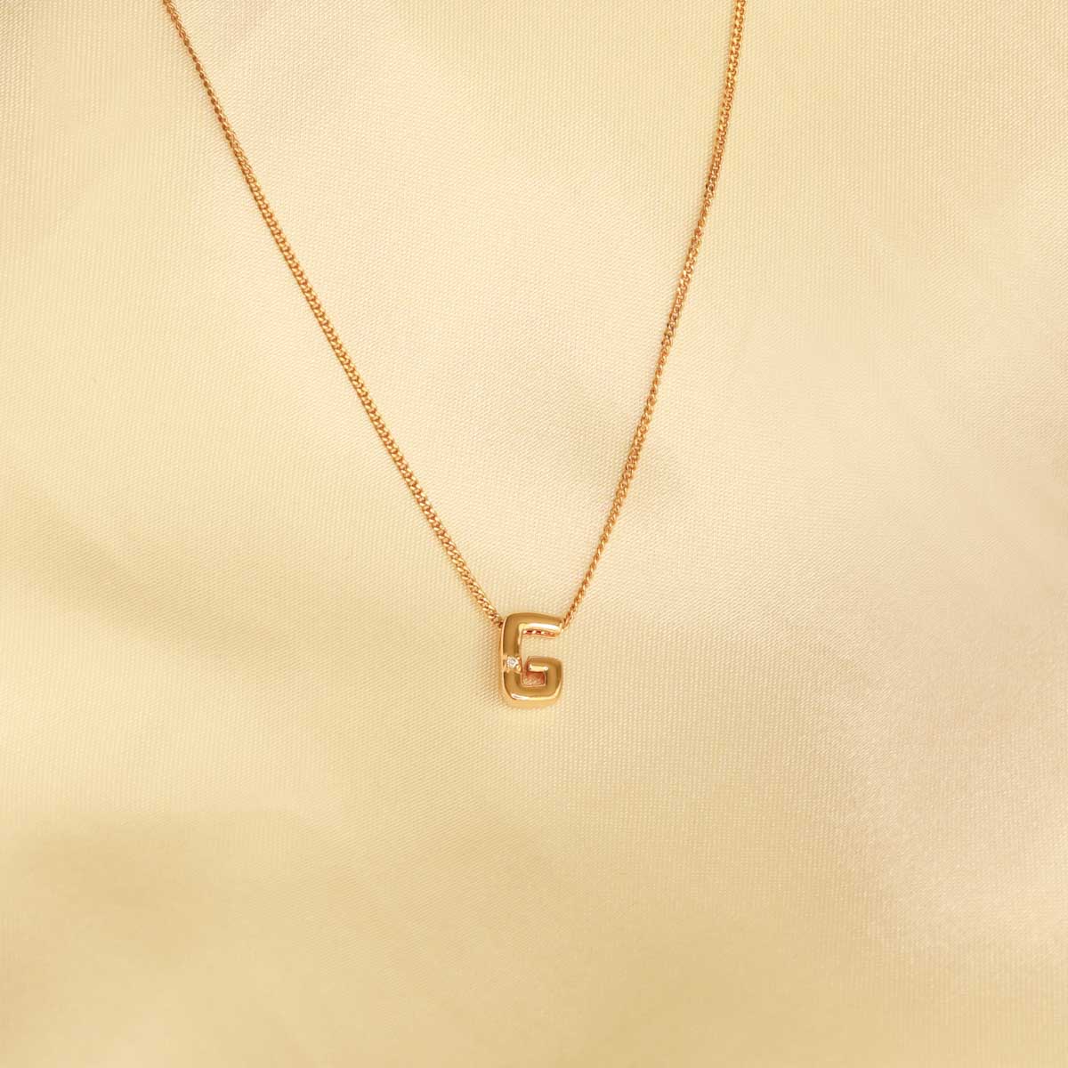 Flat lay shot of G Initial Pendant Necklace in Gold