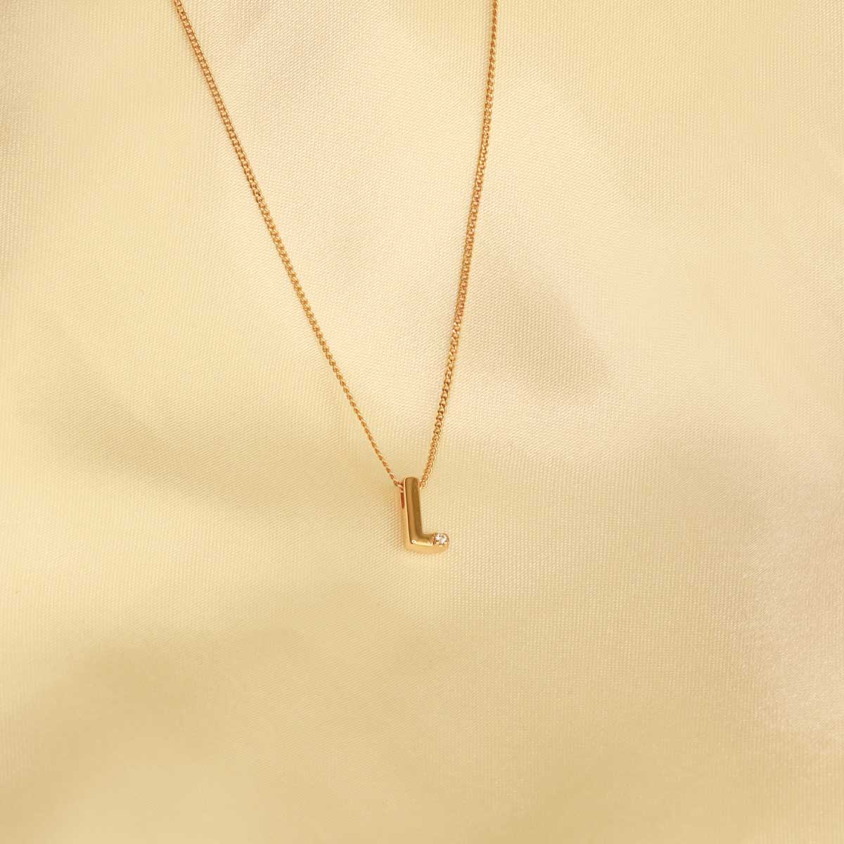 Flat lay shot of L Initial Pendant Necklace in Gold