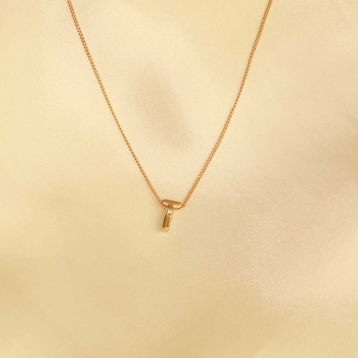 Flat lay shot of T Initial Pendant Necklace in Gold