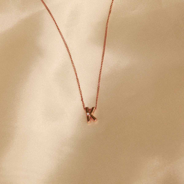 Flat lay shot of K Initial Pendant Necklace in Rose Gold