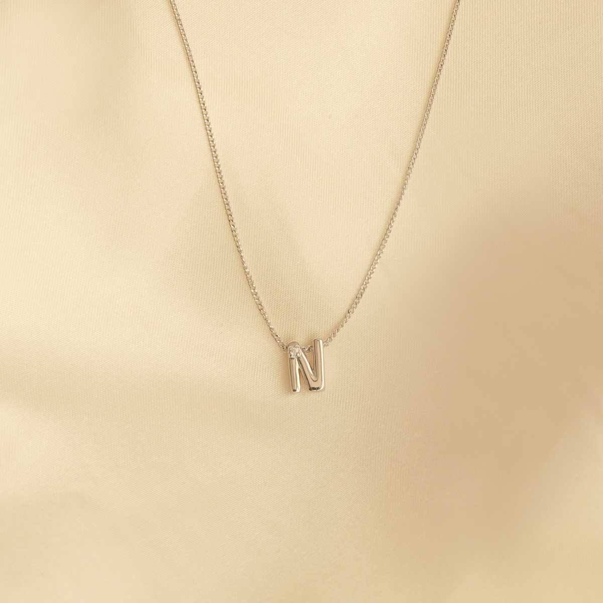 Flat lay shot of N Initial Pendant Necklace in Silver
