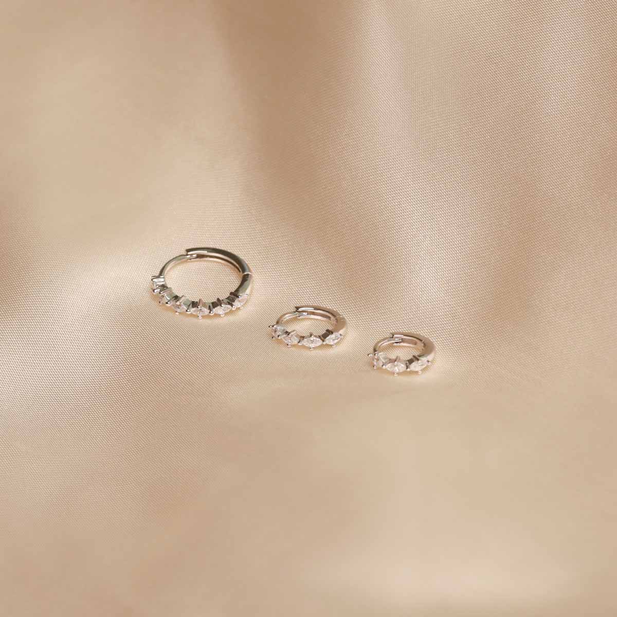 Flat lay shot of Navette Hoops in Silver in all sizes