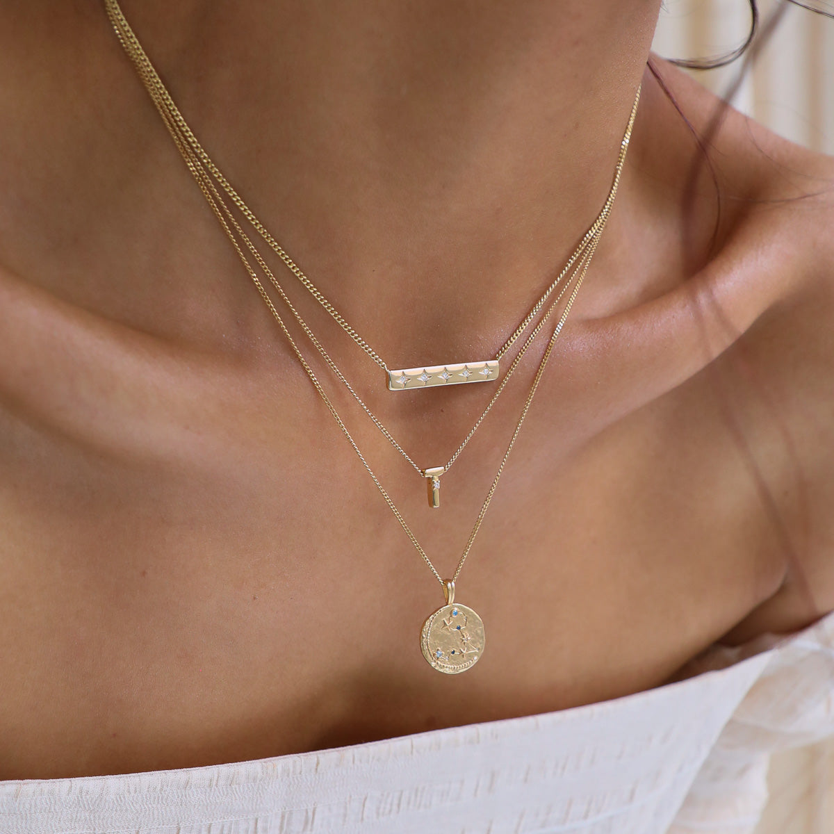 Cosmic Star Bar Necklace in Gold worn layered with initial pendant necklace and zodiac pendant necklace